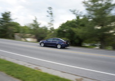 Car zooming by seemingly caught in the moment with scenery behind blured